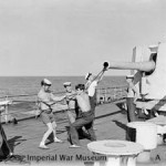 Sponging out one of the 6 inch guns of HMS KENYA after the supporting bombardment of Cheduba