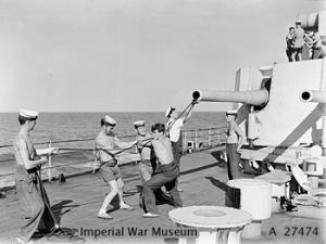 Sponging out one of the 6 inch guns of HMS KENYA after the supporting bombardment of Cheduba