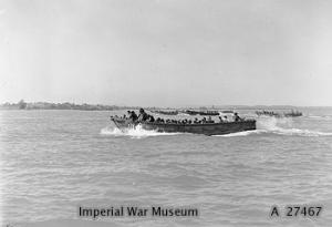 Wooden hulled assault craft with Marines on board nearing the beach at Cheduba